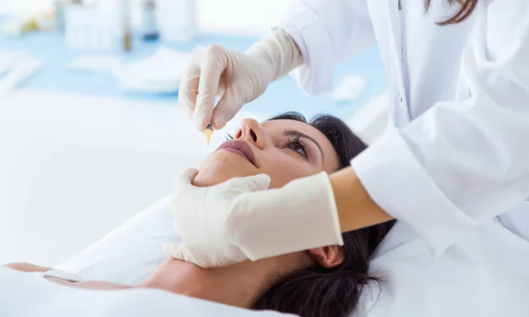 Close-up of a female patient receiving a cosmetic facial injection from a dermatologist wearing gloves in a clinical setting.